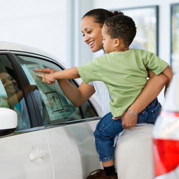 Mother and son look at a car