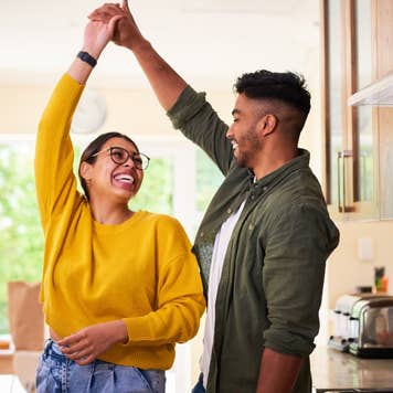 A young couple dancing together in their kitchen