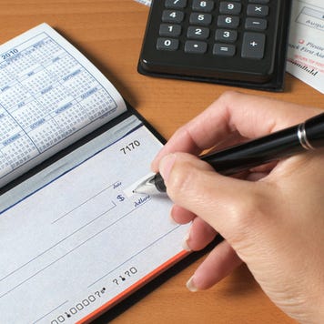 A woman writes a check